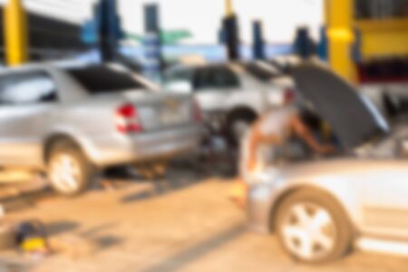 Blurred background : Car technician repairing the car in garage.の写真素材