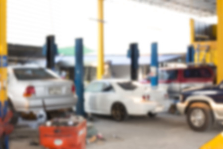 Blurred background : Car technician repairing the car in garage.の写真素材