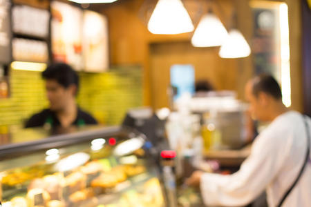 Blurred background : Vintage filter ,Barista at Coffee shop counter service blur background with bokeh.の写真素材