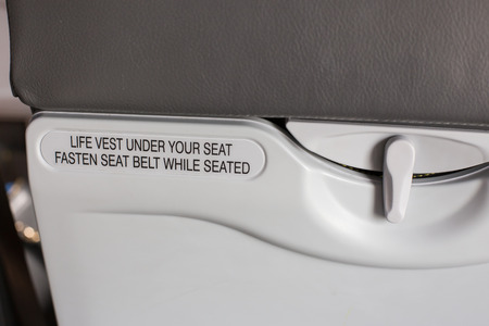 airplane seat with life vest under your seat text.の写真素材