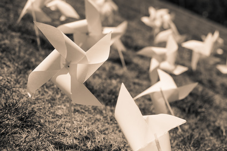 paper windmill in green grass field.の写真素材