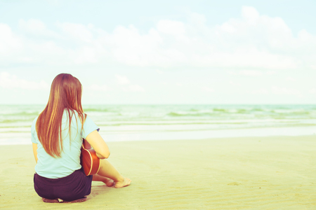 Young asian girl and ukulele on the beach, Vintage retro styleの写真素材