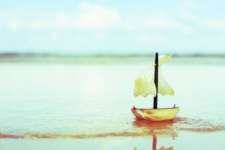 toy sail boat at the beach, Vintage retro style.の写真素材