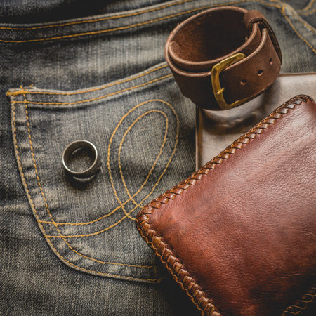 still life photography : Brown leather wallet, Leather wristbands, silver ring and adventure hat on...