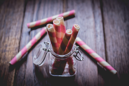 Wafer roll sticks glass bottle and wooden table.の写真素材
