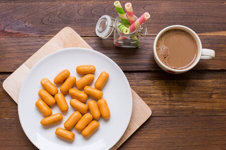 English breakfast with sausage, hot coffee, wafer stick.の写真素材