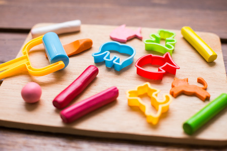 Plasticine and tools are on wooden background.の写真素材