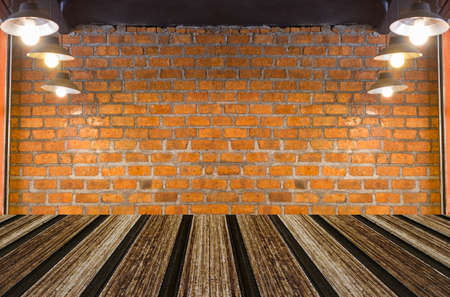 Grungy textured red brick and stone wall with warm brown wooden floor inside old neglected and deserted interior, masonry and carpentry brickwork concept.の写真素材