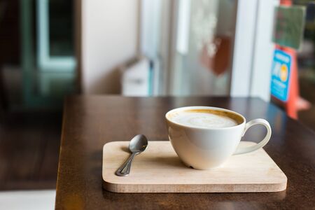 hot latte art coffee  on wooden table, vintage and retro styleの写真素材
