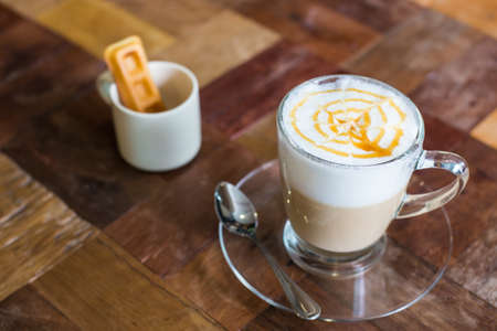 Hot art Latte Coffee in a cup on wooden table, retro and vintage effect.の写真素材