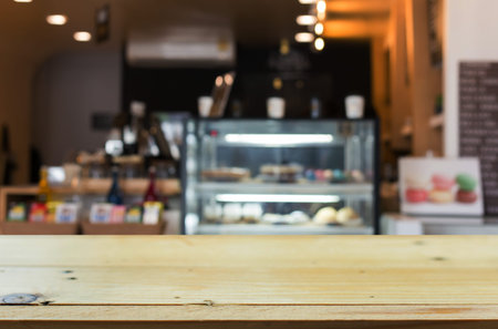 Selected focus empty brown wooden table and Coffee shop blur background with bokeh image, for...