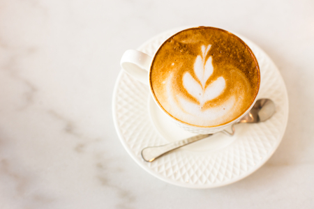 Hot art Latte Coffee in a cup on wooden table.の写真素材