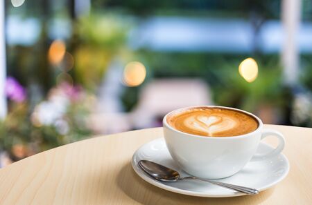 Hot art Latte Coffee in a cup on wooden tableの写真素材