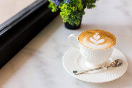 Hot art Latte Coffee in a cup on wooden table.の写真素材