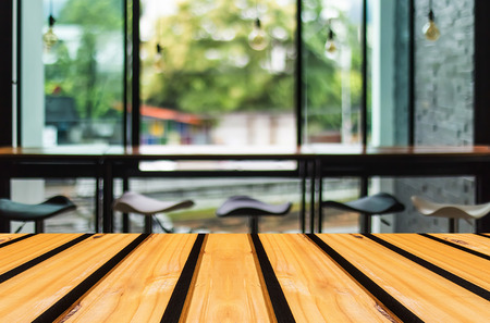 Selected focus empty brown wooden table and Coffee shop blur background with bokeh imageの写真素材