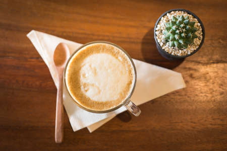 Hot art Latte Coffee in a cup on wooden table and Coffee shop blur background with bokeh imageの写真素材