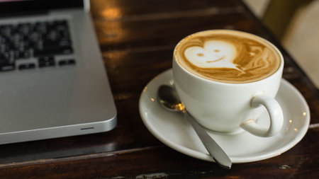 Hot art Latte Coffee in a cup on wooden table and Coffee shop blur background with bokeh image.の写真素材