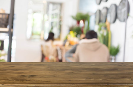 Selected focus empty brown wooden table and Coffee shop blur background with bokeh image.