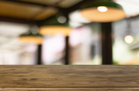 Selected focus empty brown wooden table and Coffee shop blur background with bokeh image, for product display montage.の写真素材