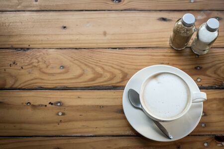 Hot art Latte Coffee in a cup on wooden table and Coffee shop blur background with bokeh image.の写真素材