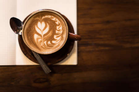 Coffee cup and notebook on grunge background.の写真素材