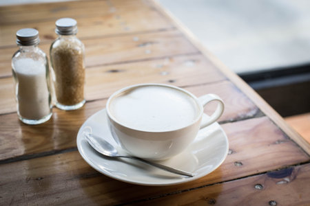 Hot art Latte Coffee in a cup on wooden table and Coffee shop blur background with bokeh image.の写真素材