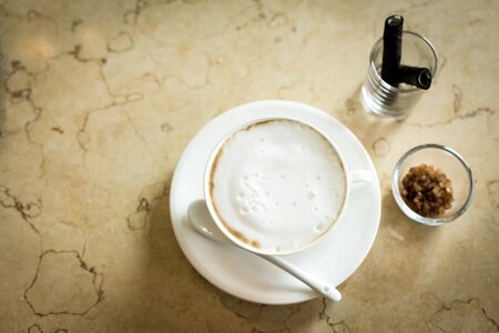 Hot art Latte Coffee in a cup on wooden table and Coffee shop blur background with bokeh image.の写真素材