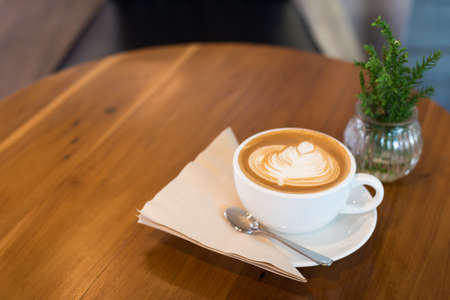 Hot art Latte Coffee in a cup on wooden table.の写真素材