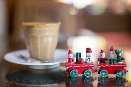 Hot art Latte Coffee in a cup and christmas toy on wooden table.
