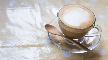 Hot art Latte Coffee in a cup on wooden table.の写真素材