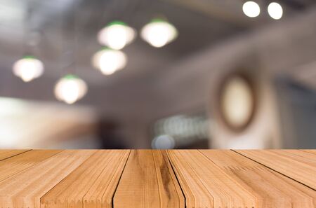 Selected focus empty brown wooden table and Coffee shop blur background with bokeh image, for product display montageの写真素材