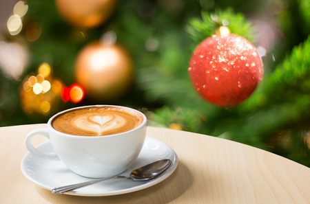 Photo of beautiful Christmas light festive, white coffee cup on the wooden table on bokeh background.の写真素材