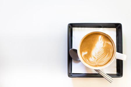 Hot art Latte Coffee in a cup and laptop on wooden tableの写真素材