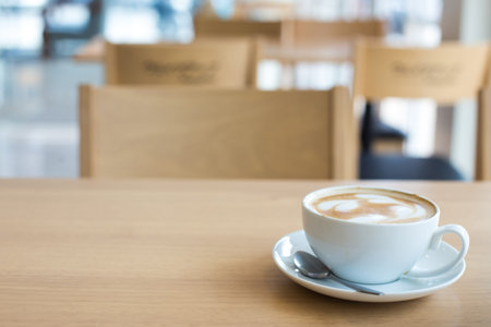 Hot art Latte Coffee in a cup on wooden table.の写真素材