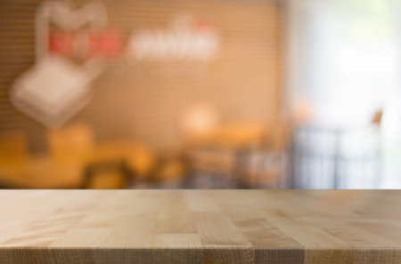 Selected focus empty brown wooden table and Coffee shop blur background with bokeh image. for your...