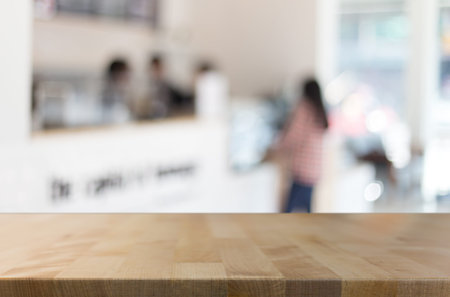 Selected focus empty brown wooden table and Coffee shop blur background with bokeh image. for your...