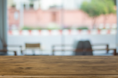 Selected focus empty brown wooden table and Coffee shop blur background with bokeh image. for your...