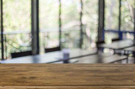 Selected focus empty brown wooden table and Coffee shop blur background with bokeh image. for your...