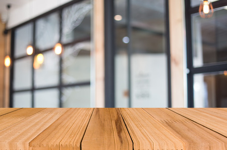 Selected focus empty brown wooden table and Coffee shop blur background with bokeh image. for your photomontage or product displayの写真素材