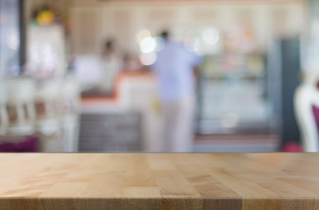 Selected focus empty brown wooden table and Coffee shop blur background with bokeh image. for your...