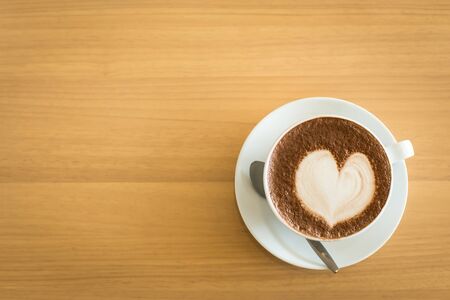 Hot art Latte Coffee in a cup on wooden tableの写真素材
