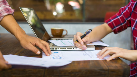 Businesspeople reviewing documents at an outdoor cafe.