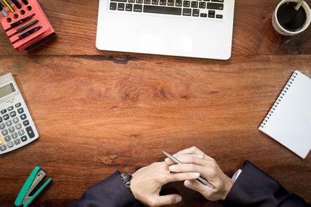 Top view of business man hands working on laptop or tablet pc on wooden desk.の写真素材