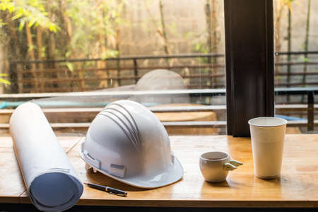 Workplace of architect - Architectural project, blueprints, blueprint, coffee cup. Engineering tools and gadgets view from the top. Construction background. vintage warm toned image with morning light.の写真素材