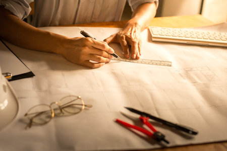 Creative architect projecting on the big drawings in the dark loft office or cafe with dark and...
