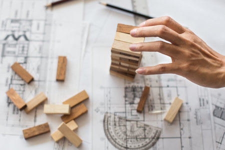 Planning, risk and strategy in business, businessman and engineer gambling placing wooden block on a towerの写真素材