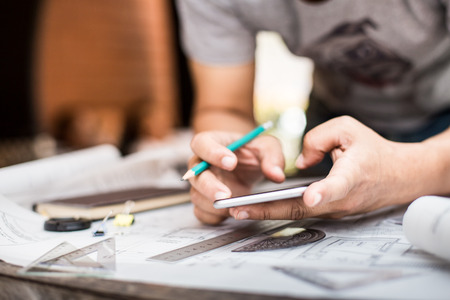 Close-up Of Person's Hand Drawing Plan On Blue Print with architect equipment.の写真素材