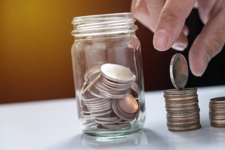 filling up coins to coin piles and glass for investment in the future.の写真素材