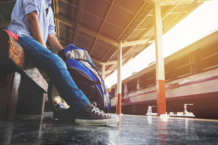 Portrait of a young man traveler waiting for train and travel bag.の写真素材