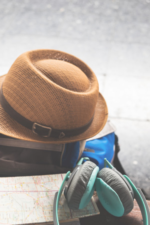 Traveler's bag map and earphone at a platform train station.の写真素材